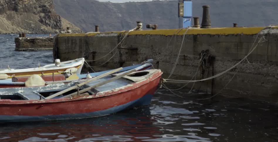 Boats jostle while being anchored at a dock
