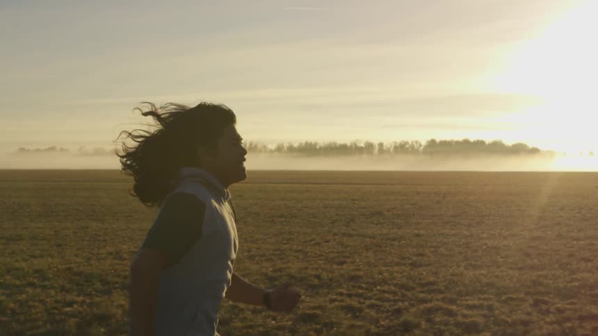A person is running outdoors at sunset