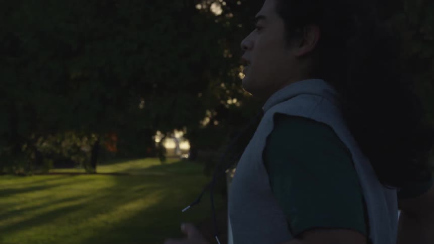 A man jogs outside in a neighborhood at sunset