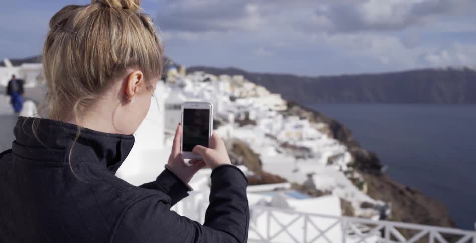 A woman takes a photograph with her smartphone