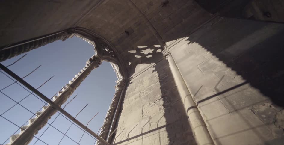 A large stone archway has open windows on a sunny day