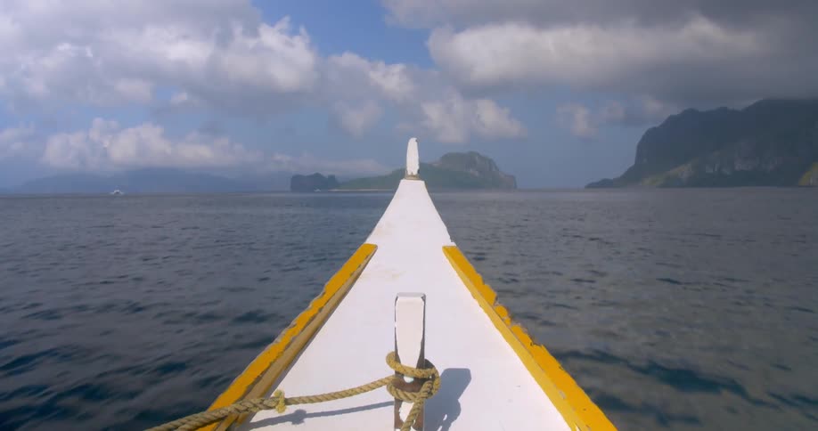 The prow of a small boat sailing on a calm day