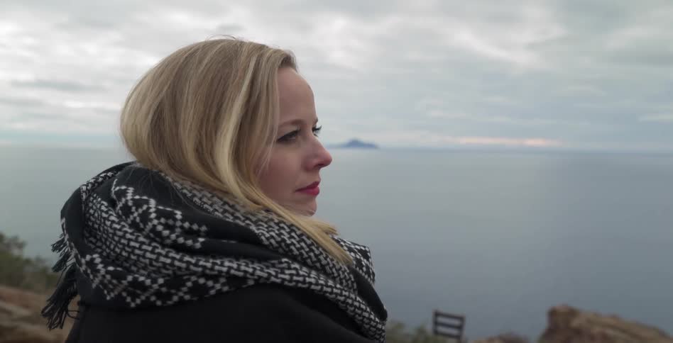 Woman looks sadly out to sea