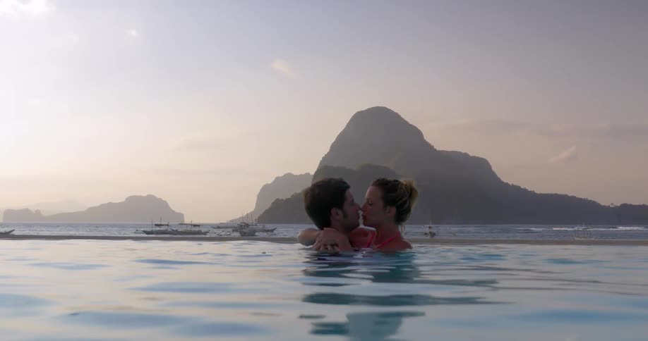 A young couple embrace and kiss in the water