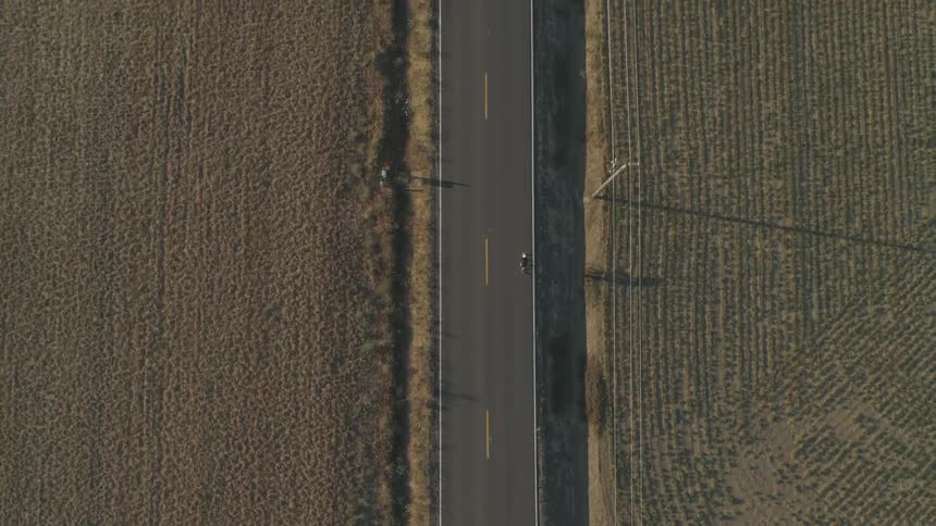 A person bicycling on a rural street