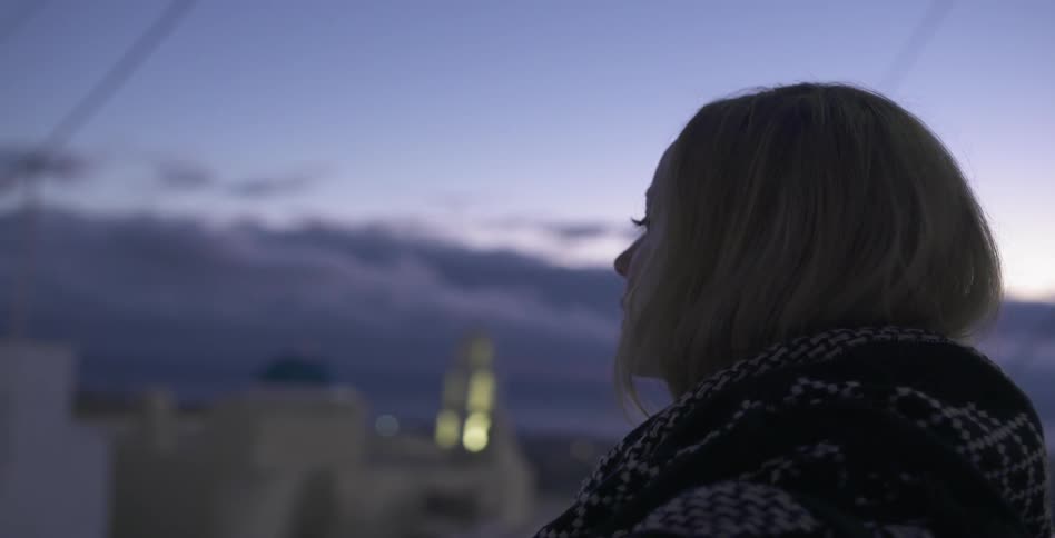 A woman looks out over a city