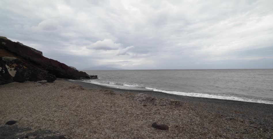 Waves touch the shoreline beside a large rock