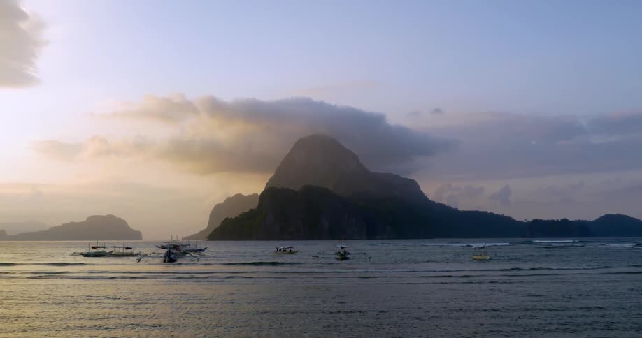 Boaters travel along a shoreline near rock formations