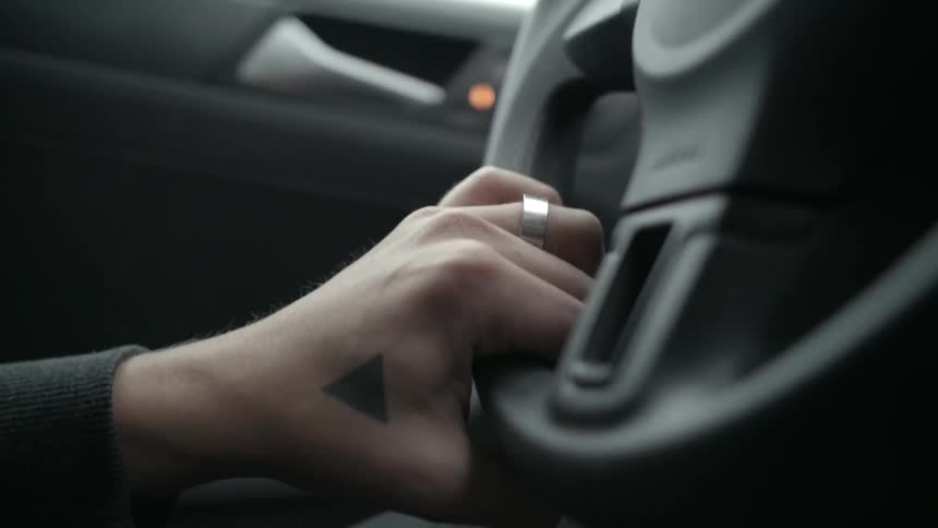 A woman holding the steering wheel of a car