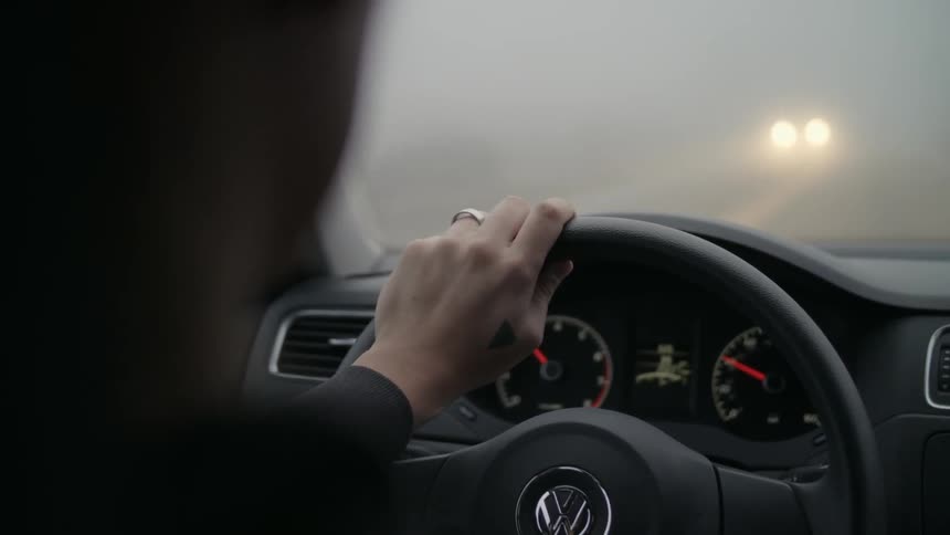 A person driving a car in heavy fog