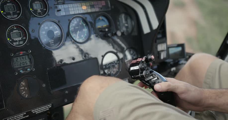 A helicopter pilot adjusts course on his joystick