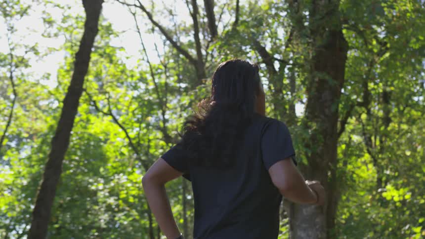 A man jogs through a wooded area