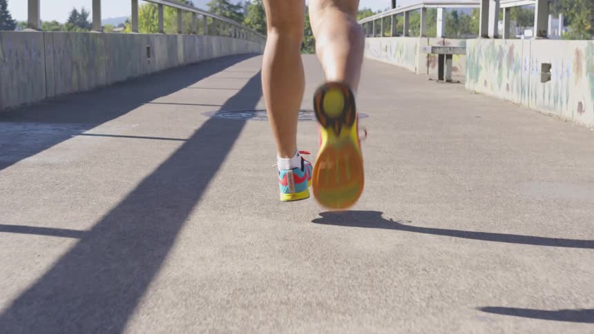 A person running down a sidewalk outdoors
