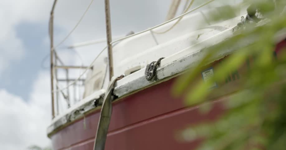 A large boat is painted red and white on a cloudy day