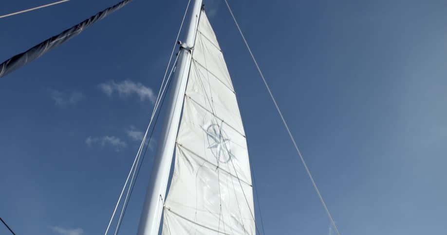 A boat sail extends towards the sky