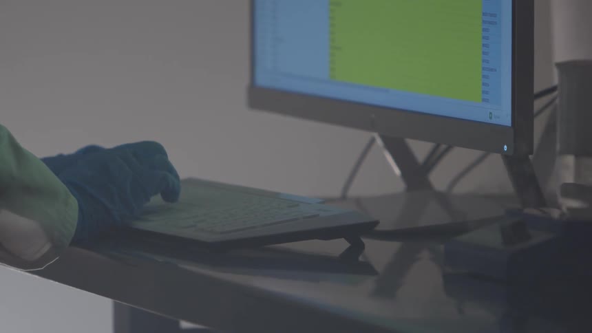 A person with gloves typing on a keyboard