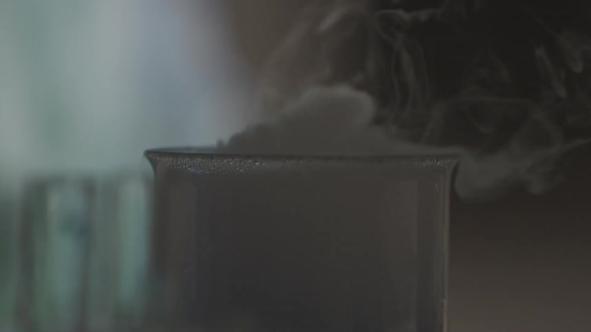 Smoke billows over lab beaker