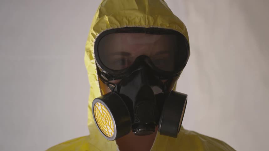 A person wearing a full gas mask and protective suit