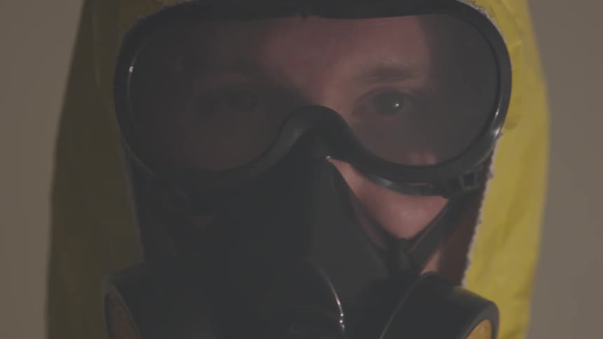 A man wears a protective yellow suit mask and goggles
