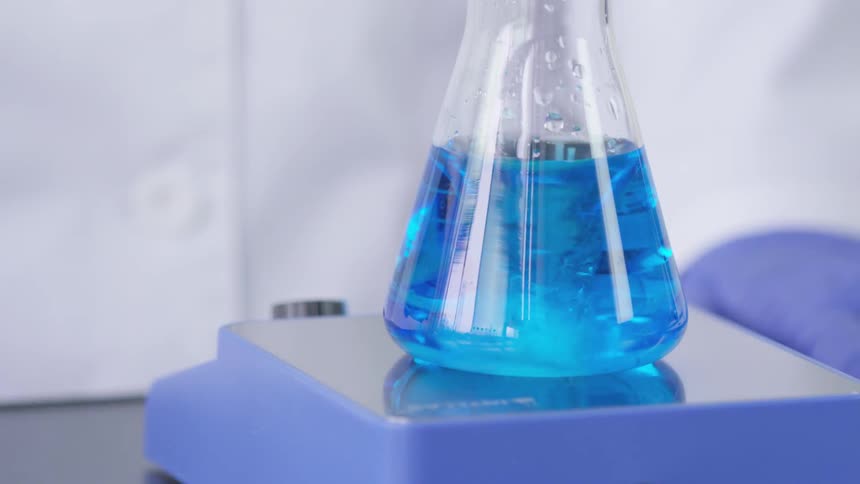 A beaker that is mixing with liquid in it inside a lab