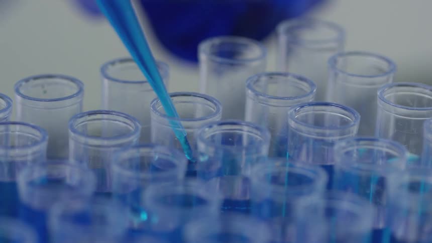 A solution is being put in to a test tube with an eye dropper