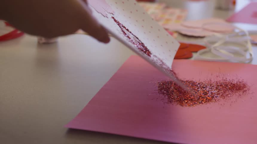 Female dumps sparkles from a piece of creative art