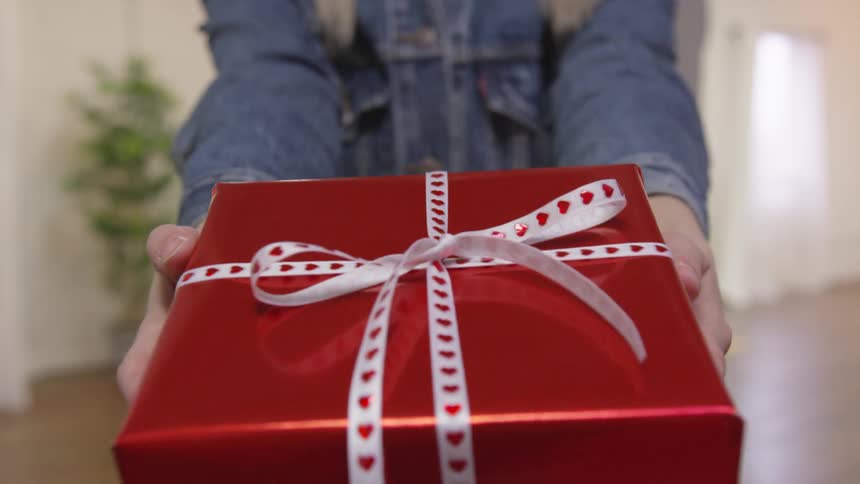 A woman is giving a present to someone