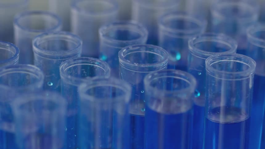 A blue chemical being put into a tube