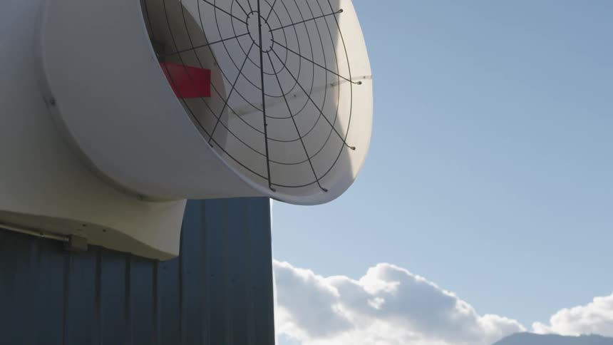 A ventilation fan on the side of a building