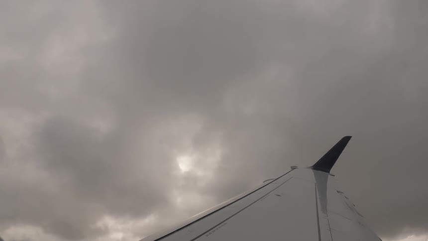 Wings of an airplane soar above the ocean