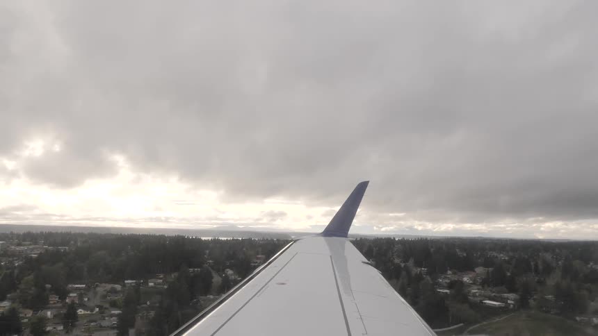 An airplane wing flying over land