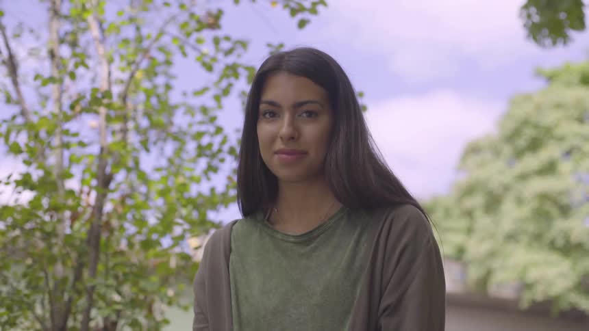 Woman standing outside looks up at the camera