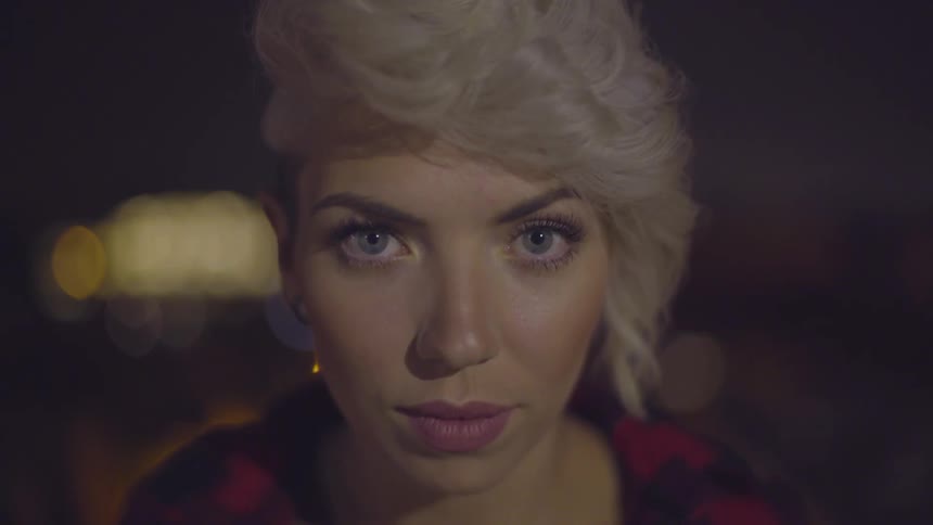 Woman with blonde hair looks up into camera