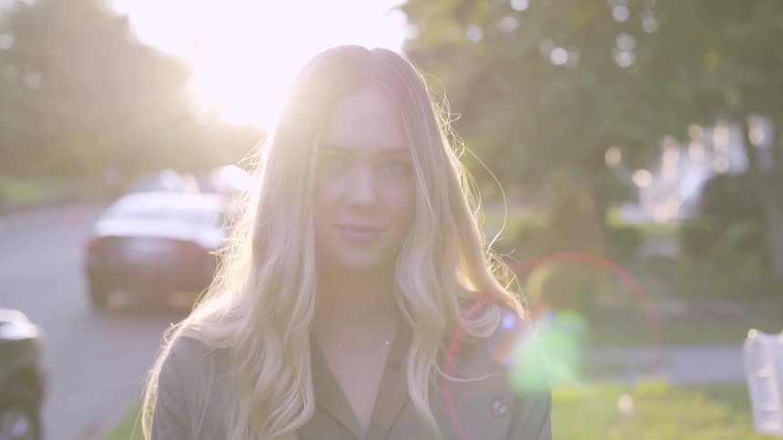A blonde woman standing out on the sidewalk