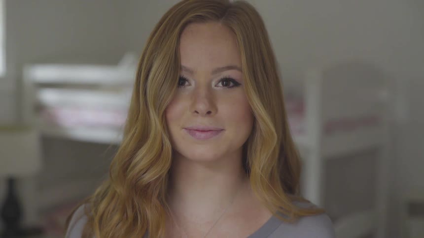 White female with long blonde hair looking up and smiling
