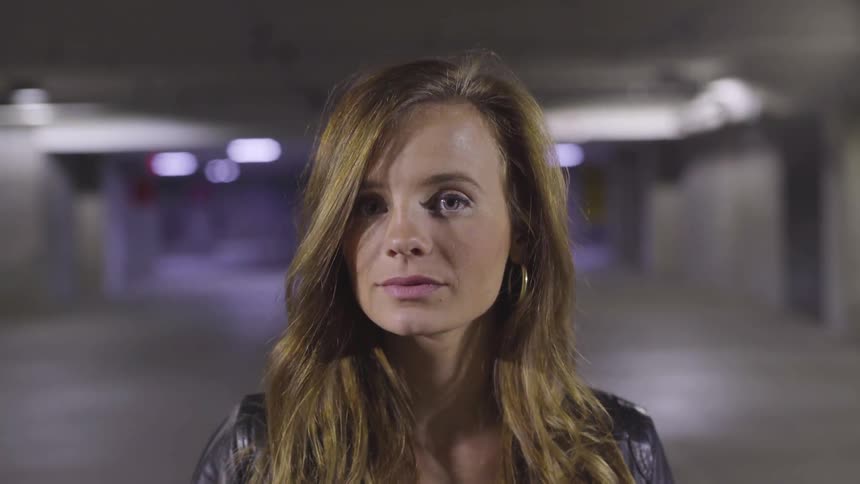 A woman standing in a parking garage