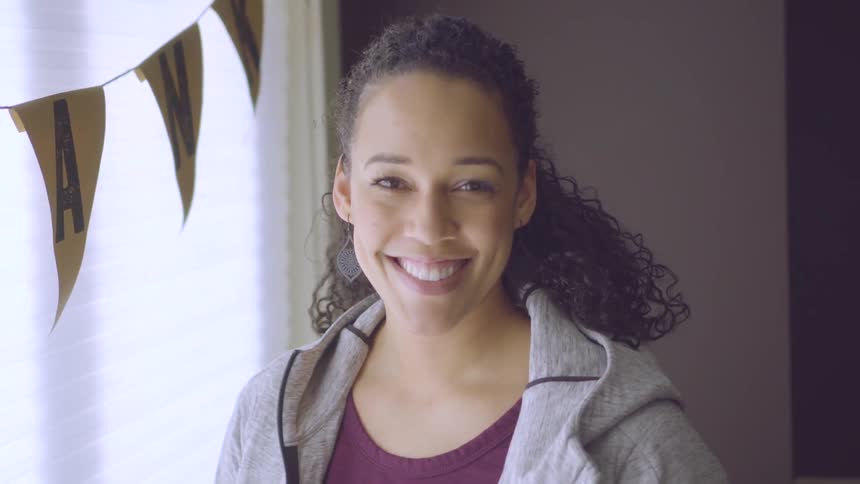 Young woman grins and looks at camera
