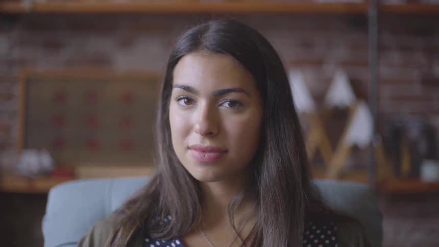 A woman turns her face forward from looking to the right