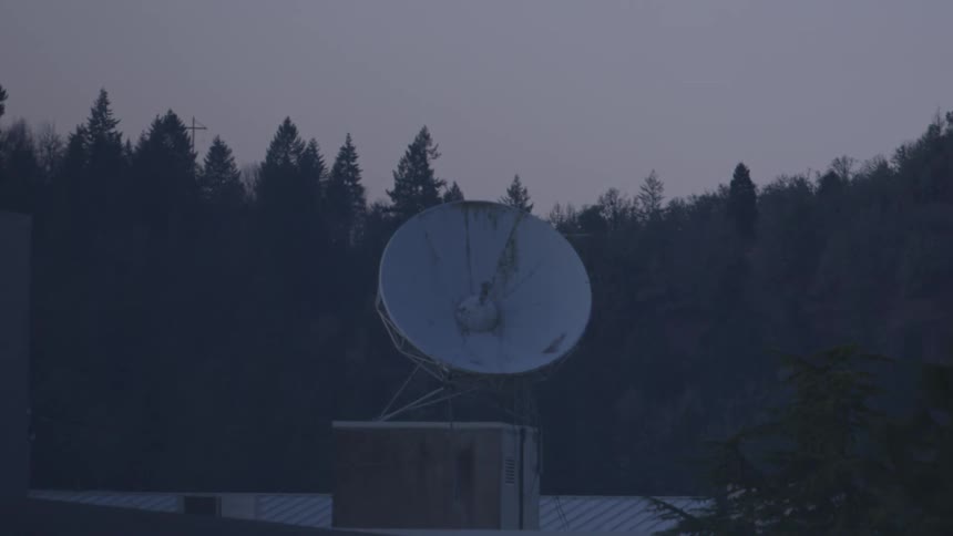 A large satellite dish on top of a building
