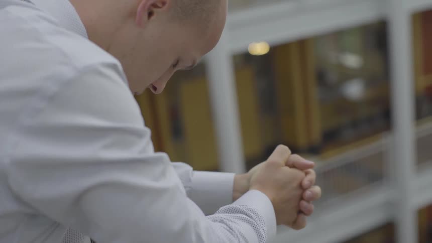 A man in a shirt and tie praying