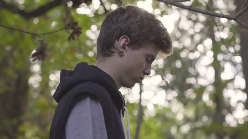 A boy is standing outdoors at midday