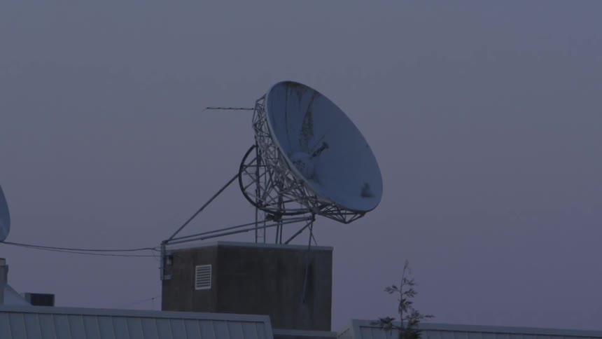 A satellite sits above a building