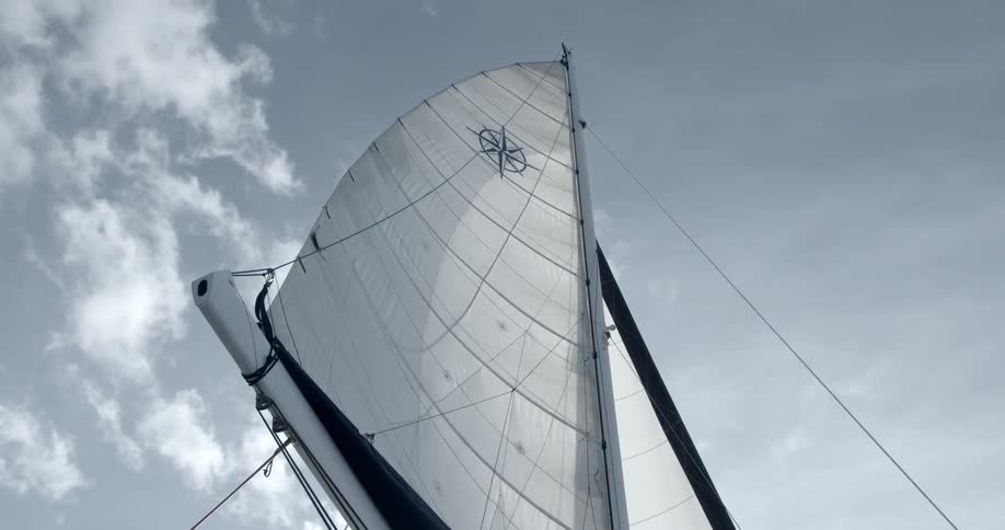 A large sail is high in a cloudy sky