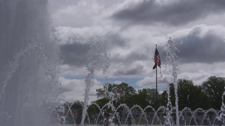 A lone flag sits among a water fountain