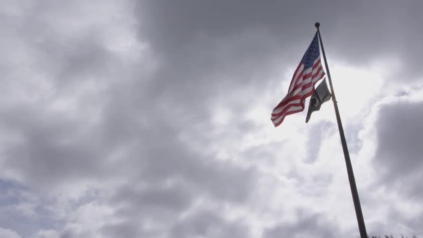 The us flag waving in the wind under a cloudy sky
