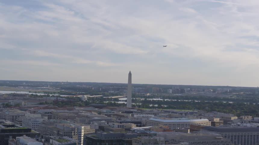 A plane flying over the washington monument