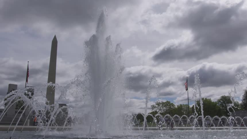 Flags in the breeze behind a large city fountain