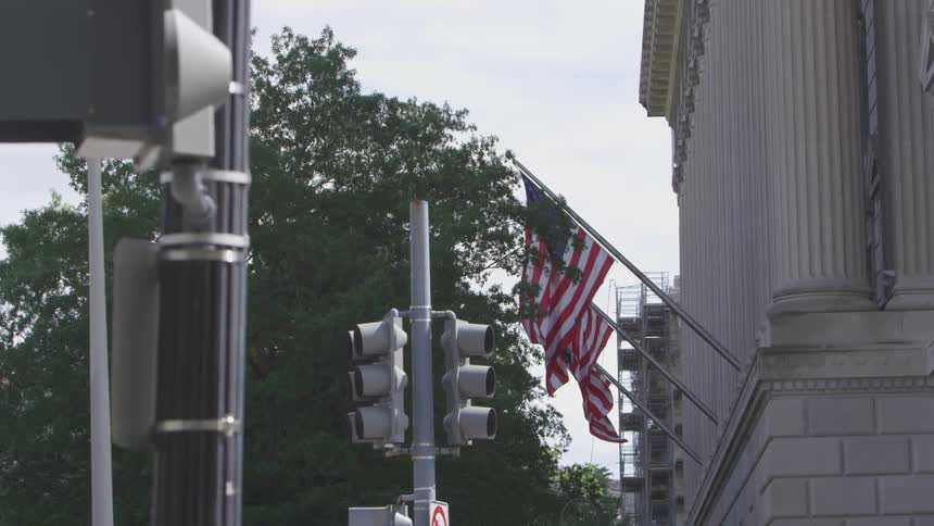 Flags wave in the wind in front of a building