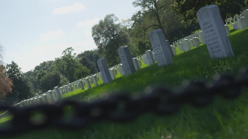 Headstones neatly lined on a grassy cemetery