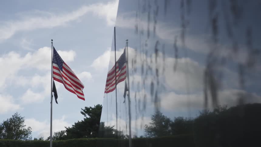 Flags that are reflecting off of a glossy wall